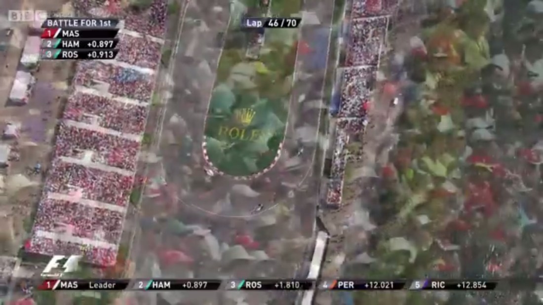 The 2014 Canadian Grand Prix: Lewis Hamilton gives the lead away to Nico Rosberg as the camera cuts away to a crowd shot.